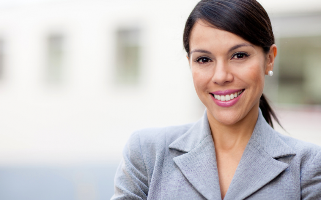 Female business woman in grey suit smiling at the camera