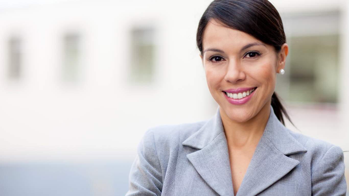 Female business woman in grey suit smiling at the camera